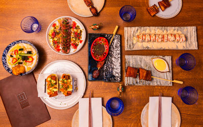 A wooden table laid out with Japanese-Peruvian dishes at Brighton restaurant