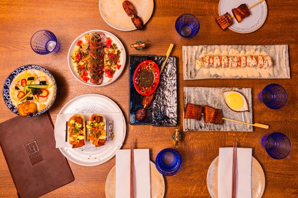 A wooden table laid out with Japanese-Peruvian dishes at Brighton restaurant
