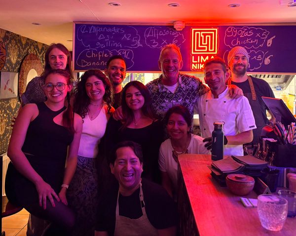 A group of peopl inside Brighton restaurant with a neon sign in the background
