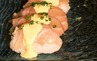 sushi and salmon. presented on a black plate at LimaNikkei