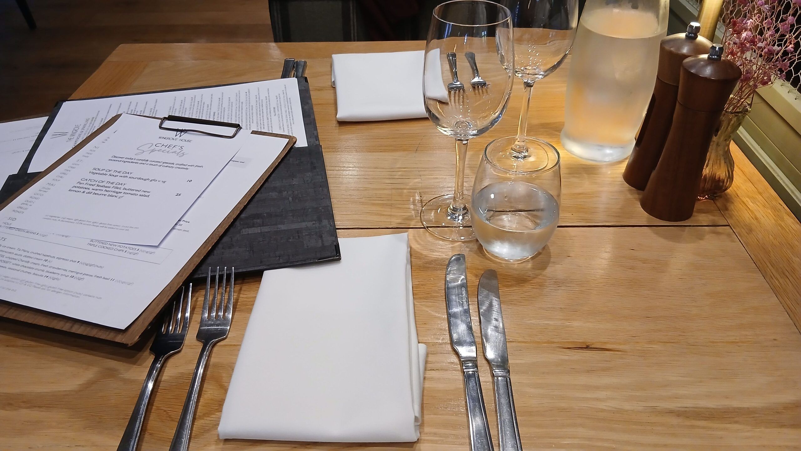 over head shot of the dining table that has cutlery, glasses and menus on it