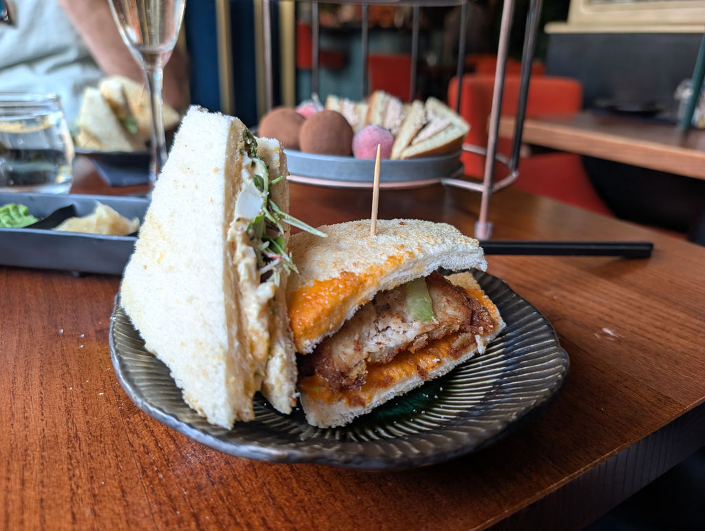 Two sandwiches from the tiered Japanese tea stand with the sweet dish in the background.
