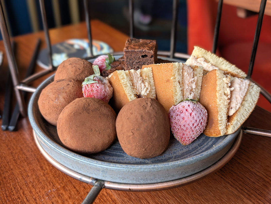 The sweet tier of a Japanese inspired afternoon tea including mochi balls and strawberries.
