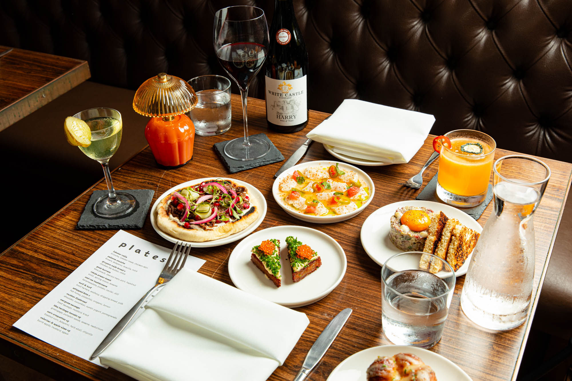 over head shot of the small plates, cocktails and wine served on the table at Plates Brighton