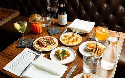 over head shot of the small plates, cocktails and wine served on the table at Plates Brighton