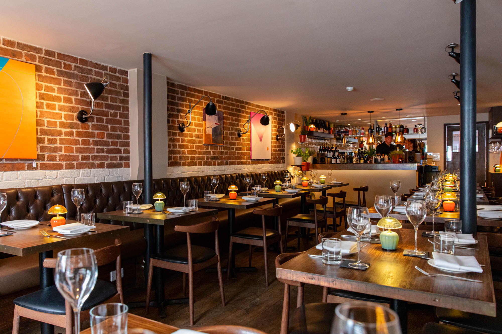 interior shot of the Plates Brighton, wooden tables, dim lights and paintings on the wall