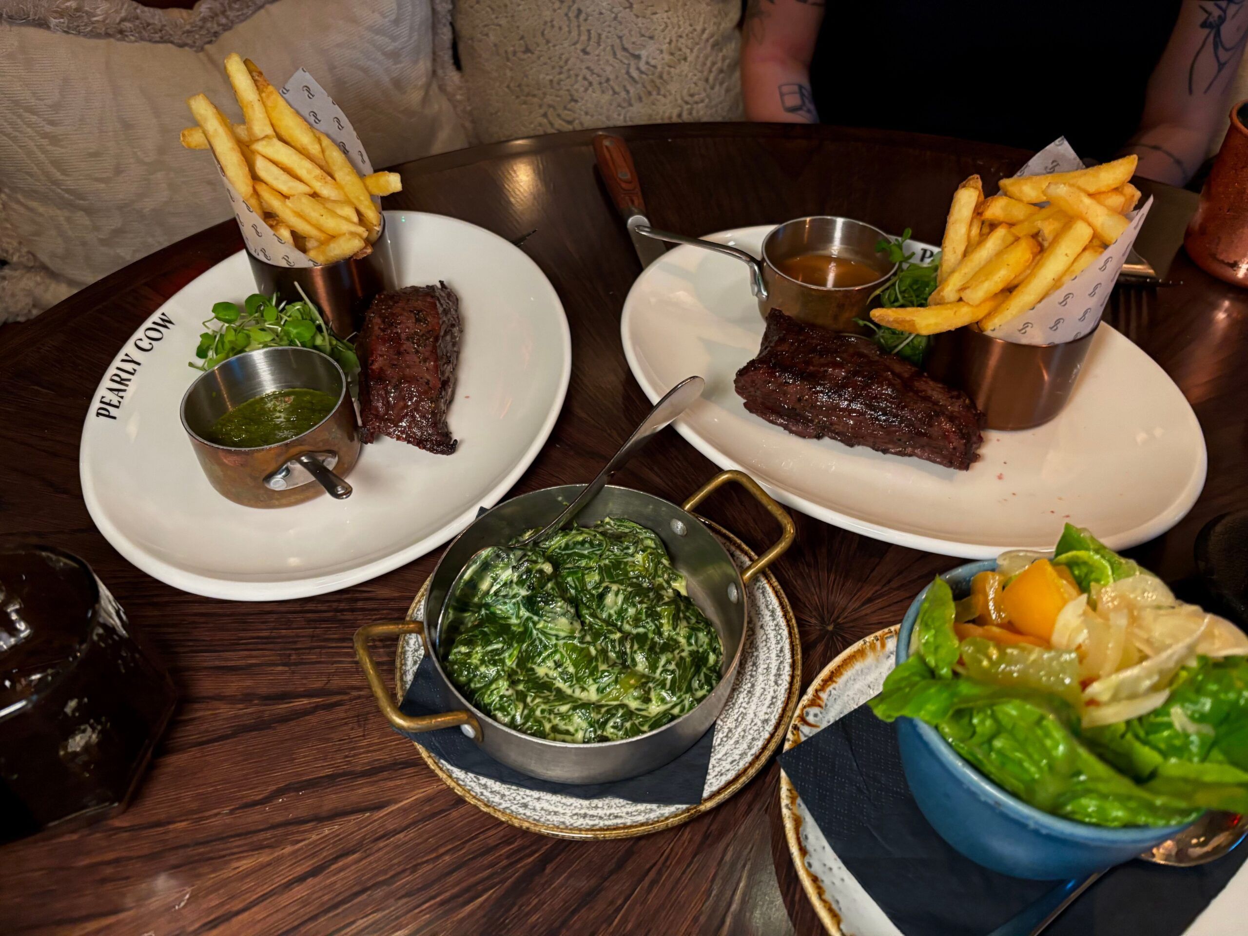 shot of the plates with chips and sreaks served during Steak Night at Pearly Cow