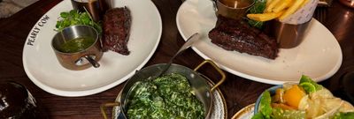 shot of the plates with chips and sreaks served during Steak Night at Pearly Cow