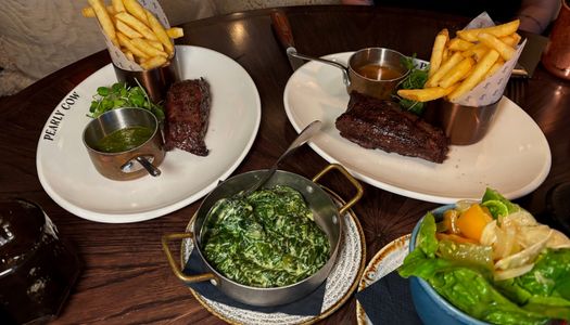 shot of the plates with chips and sreaks served during Steak Night at Pearly Cow