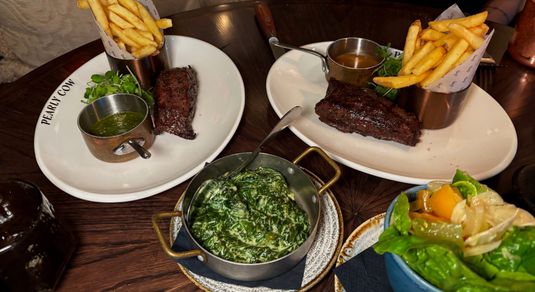 shot of the plates with chips and sreaks served during Steak Night at Pearly Cow