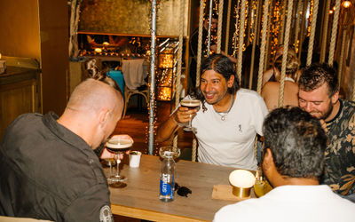 People sat around a table drinking cocktails inside Mowgli Brighton