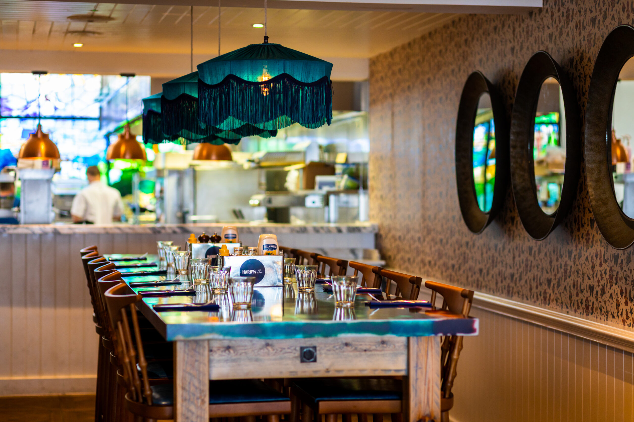 side shot of the long wooden table and chairs at Harbar Brighton